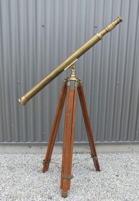 an antique brass telescope on a wooden tripod stand