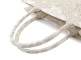 a white bag with a handle that has a name on it