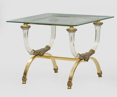 a brass and glass side table with two birds on it