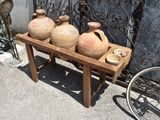 three vases sitting on a wooden stand next to a bike