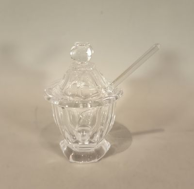 un bocal en verre contenant une cuillère, posé sur une table