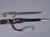 deux couteaux et une corde posés sur une surface blanche