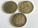 trois pièces de monnaie britanniques empilées les unes sur les autres sur une surface blanche