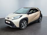 un SUV Toyota C-HR beige garé dans une pièce blanche