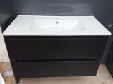 a white sink sitting on top of a black cabinet