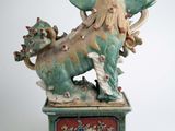 a statue of a dragon on a pedestal on a white background