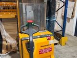 a forklift in a warehouse with pallets in the background