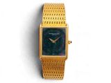 une image d'une montre-bracelet en or sur une surface blanche