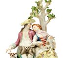 une figurine représentant un homme et une femme assis sous un arbre