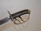 a close up of a sword on a white surface