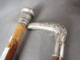 a silver cane with a wooden handle on a table