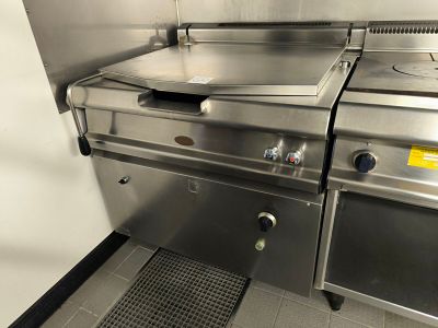 deux cuisinières en acier inoxydable dans une cuisine au sol carrelé