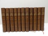 six brown books are lined up on a white surface