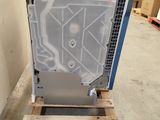 an image of a dishwasher sitting on a pallet in a warehouse