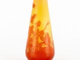 a yellow vase with red flowers on it on a white surface
