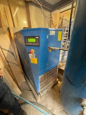 un homme qui se tient debout devant une machine bleue