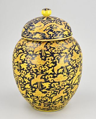 une image représentant un vase jaune et noir orné d'oiseaux