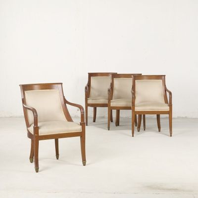 quatre chaises dans une pièce aux murs et au sol blancs