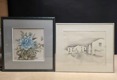 two framed drawings of a house and a flower on a table