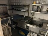 une cuisine avec un évier et beaucoup de vaisselle sur le plan de travail
