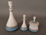 three white and blue vases sitting on a table