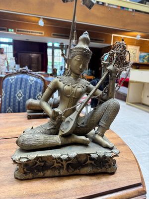 a statue of a woman playing a musical instrument on a table
