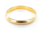 gros plan d'une bague en or sur une surface blanche
