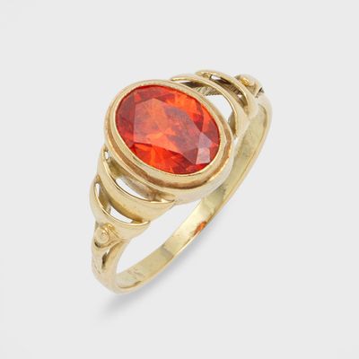 gros plan d'une bague en or avec une pierre rouge