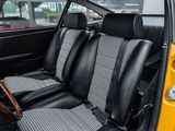 a yellow car with black and white seats in a parking lot