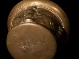 a close up of a bronze knob on a black background