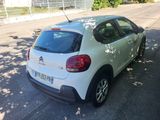 the back of a white car parked on the side of the road