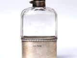 an antique silver and glass perfume bottle on a white surface
