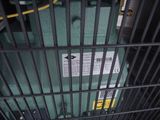 a green box in a cage with a sign on it