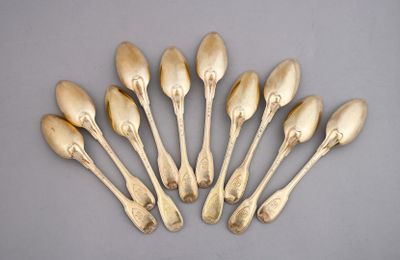 six gold spoons are arranged in a circle on a gray surface