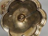 a silver vase with a gold flower on it