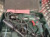 a green tool box with tools in it on a table