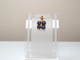 une boucle d'oreille bleue et dorée présentée dans une vitrine transparente
