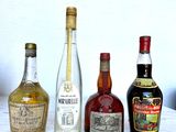several bottles of liquor are lined up on a marble table