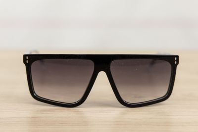 a pair of black sunglasses sitting on top of a wooden table