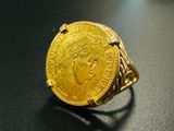 une image représentant une bague en or sur laquelle repose une pièce d'or