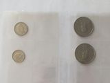 three coins in a clear plastic bag on a white surface