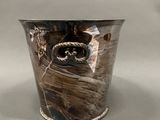 a silver vase with a picture of a boat on it