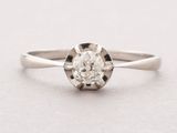 a close up of a diamond ring on a white surface