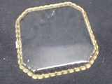 a glass tray with a mirror on it on a black surface