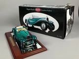 a model of a green car on a wooden stand