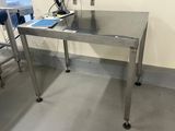 une table sur laquelle se trouve un ordinateur portable, dans une pièce