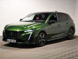 La voiture verte est garée dans une pièce dont le sol est en damier.