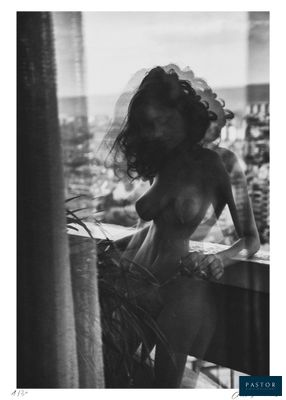 a black and white photo of a woman standing on a balcony