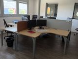 a desk with two computers and a chair in an office