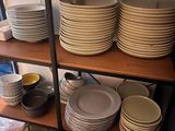 many plates and bowls on a shelf in a room